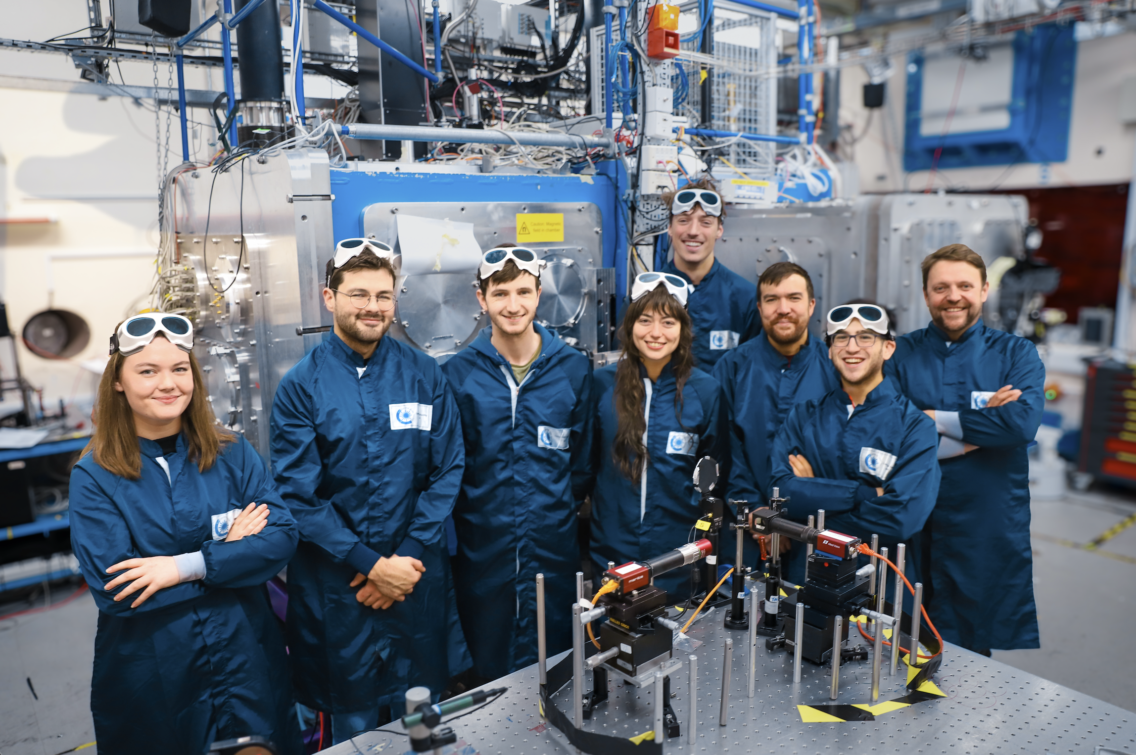 Group of scientists by laser equipment